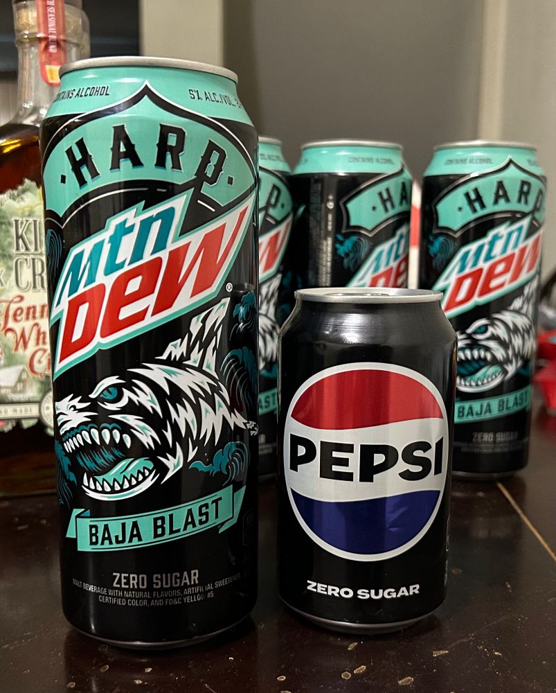 Hard mtn dew Baja blast beside standard zero sugar Pepsi can for size comparison 