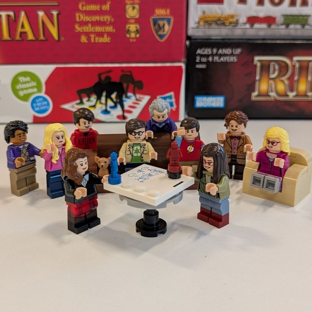 LEGO Minifigs play a game in front of board game boxes.