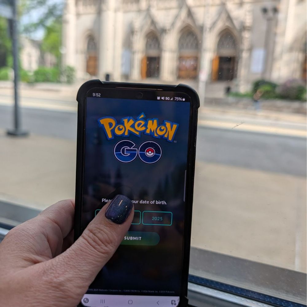 Hand holding phone with Pokemon Go logo visible.