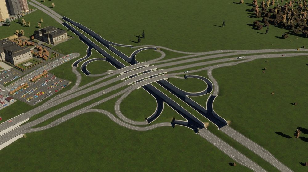 A screenshot of a cloverleaf intersection where the road going north to south goes into the ground under the road going west to east