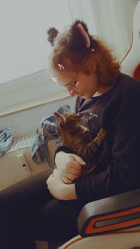 Isa mit Katzenohren schaut Milli (meine Katze) an 