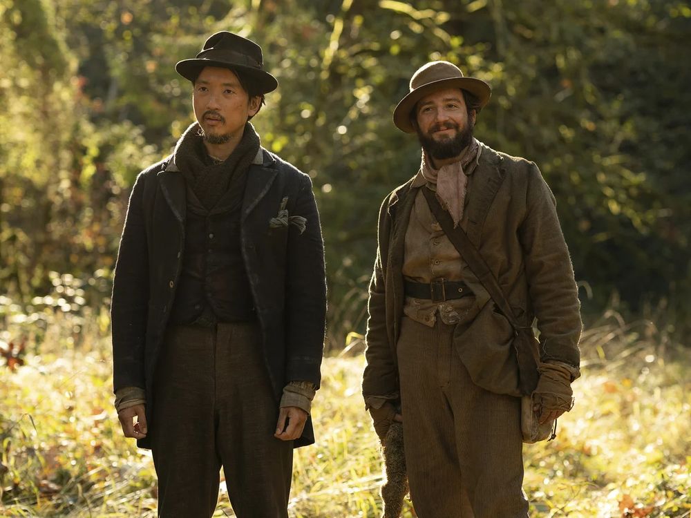 King-Lu (Orion Lee) and Cookie (John Magaro) stand in the wilderness