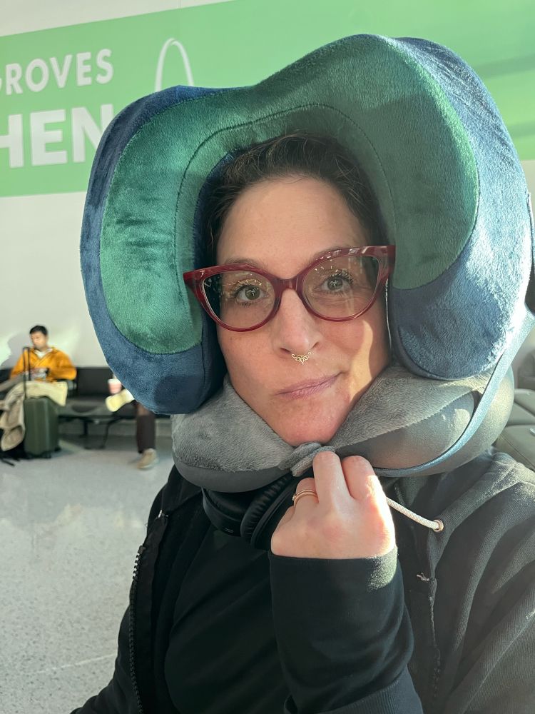 Cat at the gate, waiting to board the flight to Helsinki, OUR NEW HOME WTF. She’s wearing a neck pillow on her neck and another around her head. You know, for comfort. 