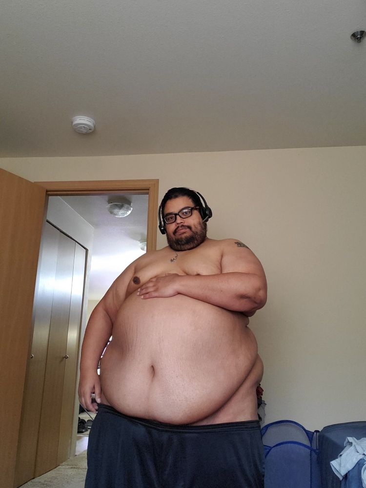 Fat guy showing off his belly while shorts are pulled down partially.