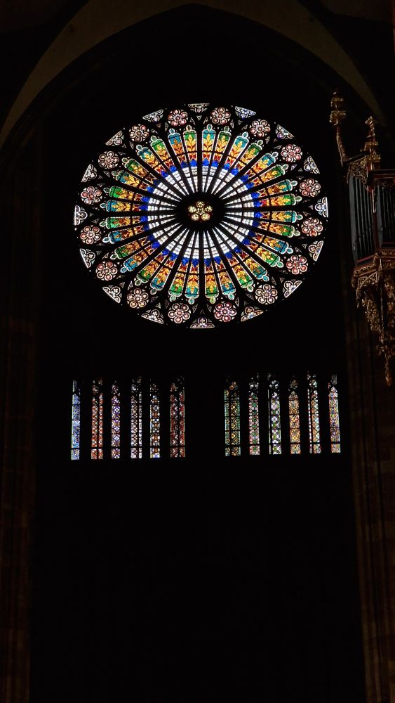 Vitrail principal de la cathédrale de Strasbourg présentant une rosace de verts de rouge de bleu et de jaune