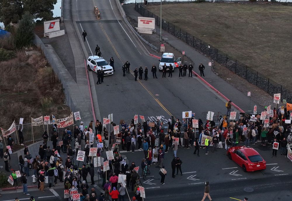 Protesters walk back and forth blocking road to Coast Guard Island. (Photo credit Justin Sullivan/Getty Images)