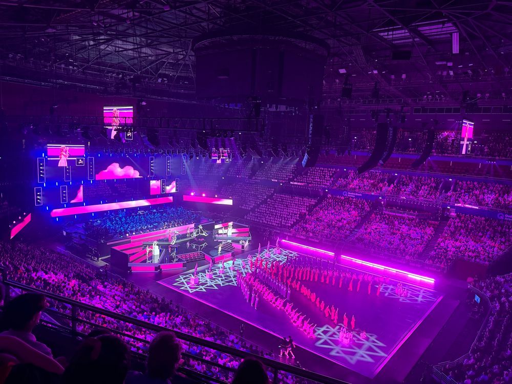 Another image of the show from the audience. Students in an arrow formation, with the lights making everything pink. 