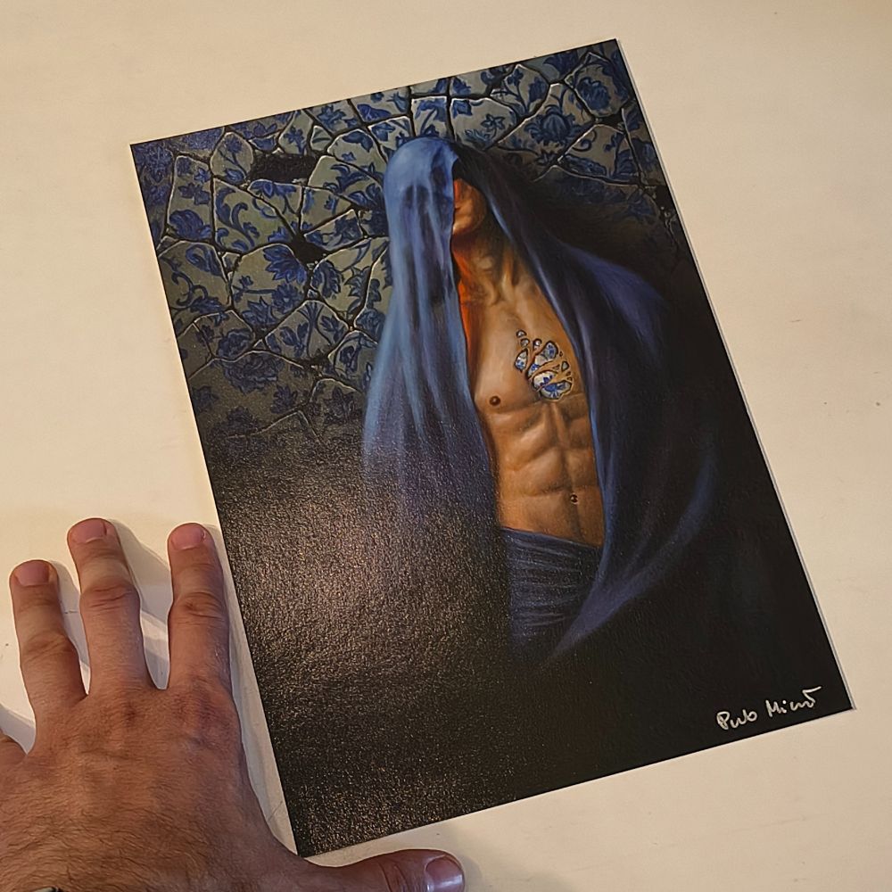 Photo of an art print of the painting. A man standing against a broken porcelain wall, he's wearing a blue fabric draped from his head, instead of his face there is a skull visible under the fabric. There is a porcelain heart visible on his chest.

There is my hand visible next to the print.