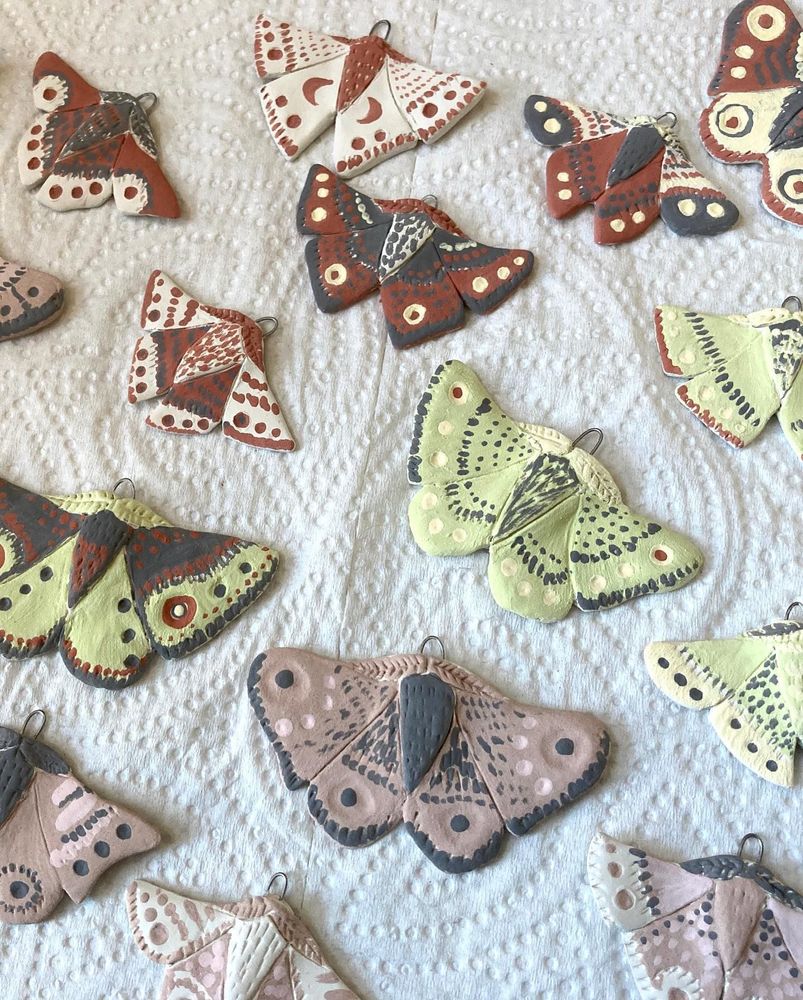 Several porcelain moths of various colors before glazing