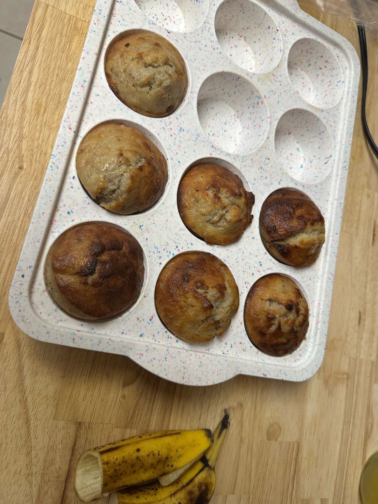 My brothers banana bread muffins in a silicone muffin pan sitting on a large wood cutting board 