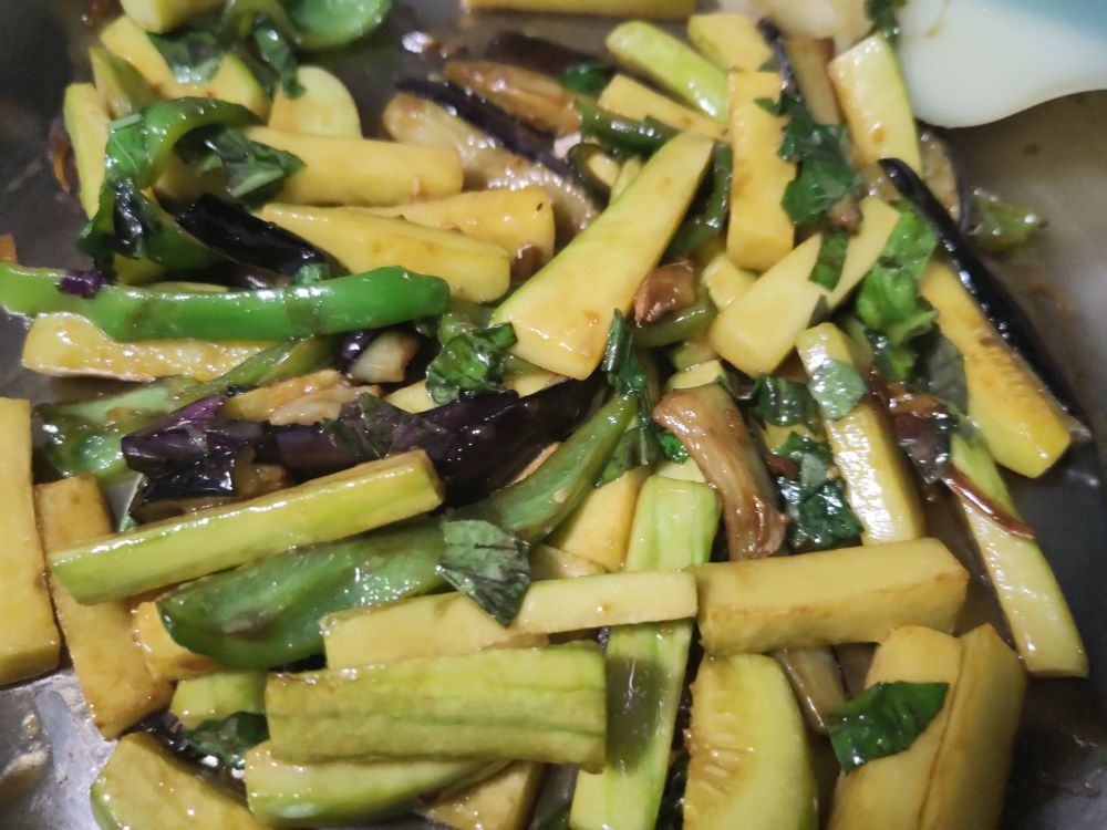 Photo of a stir fry using the veggies mentioned chopped into strips, with homemade sauce a Thai basil thrown in at the end
