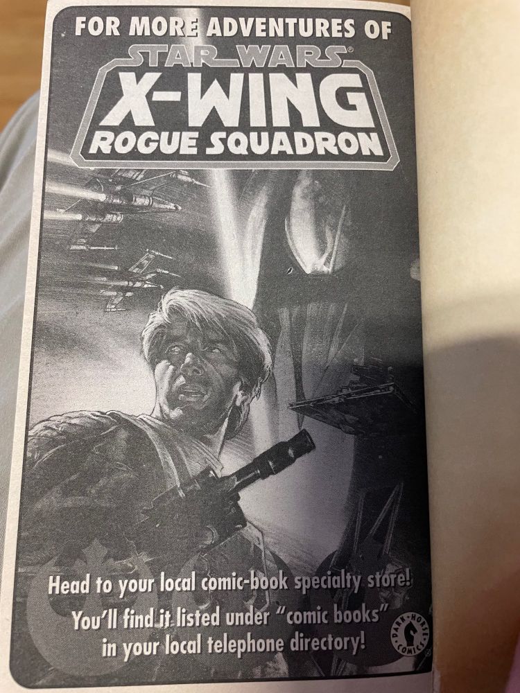 Photo of an ad telling people to look in a phone book to find a comic store.