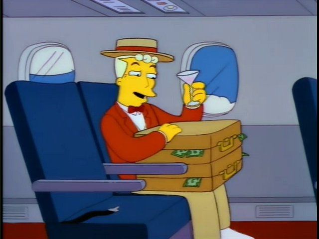 Lyle Lanley sitting on a plane with suitcases full of money 