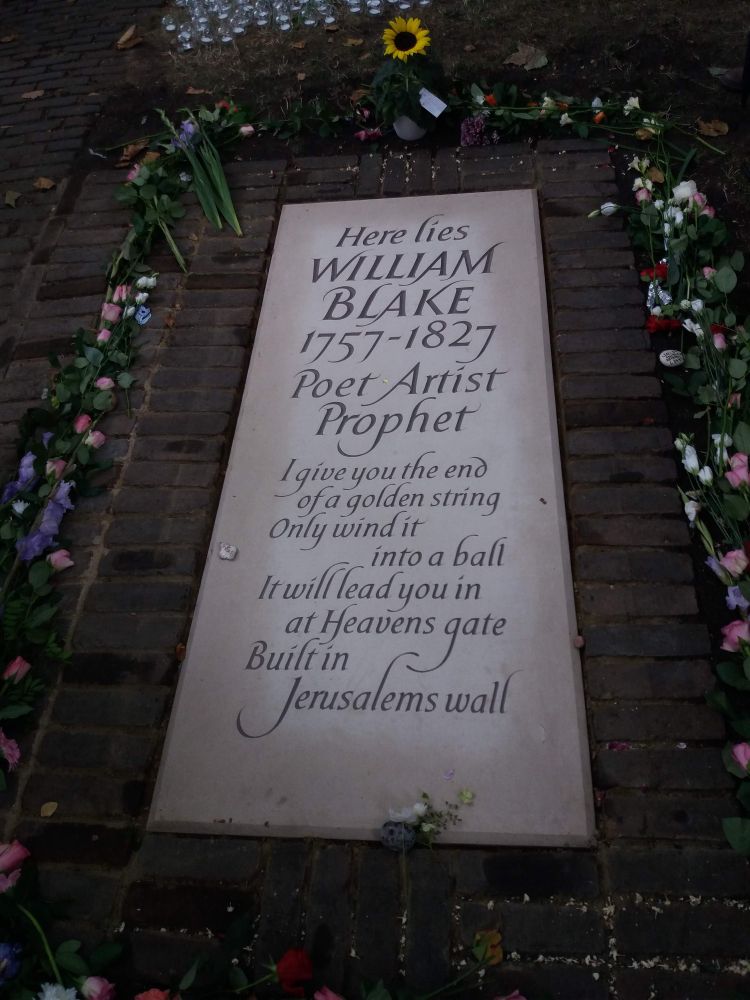 William Blake's grave, surrounded by flowers and candles, on the day it was unveiled by the Blake Society in 2018.