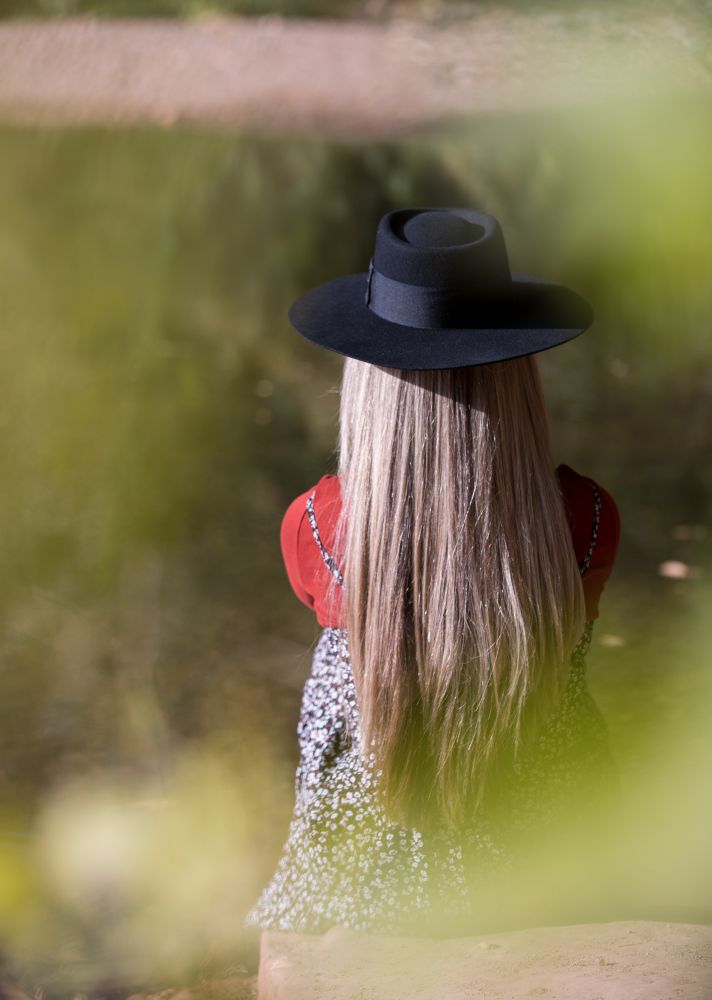 Girl w hat standing w her back to the camera