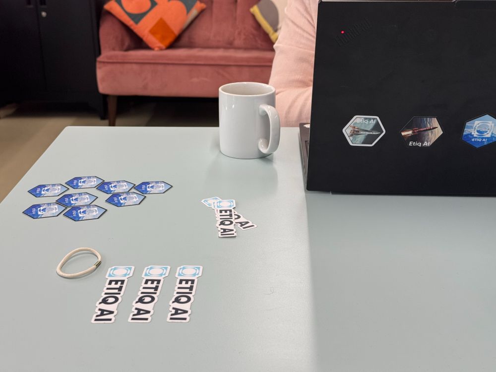 Stickers neatly arranged on a desk with stickers also on a laptop