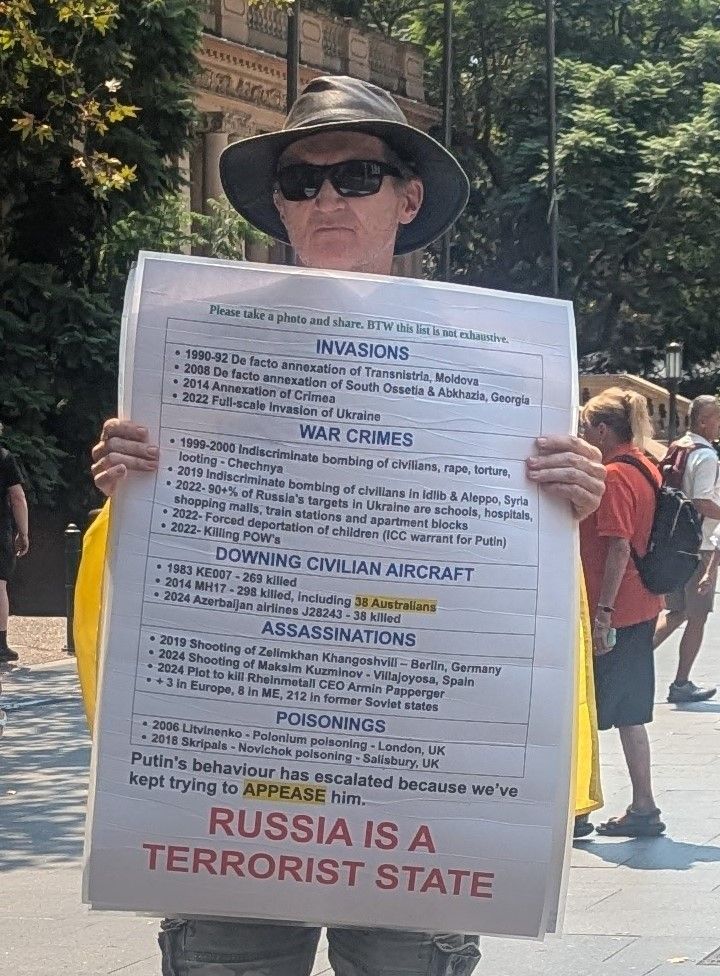 Australian protester displays anti-Putin poster.