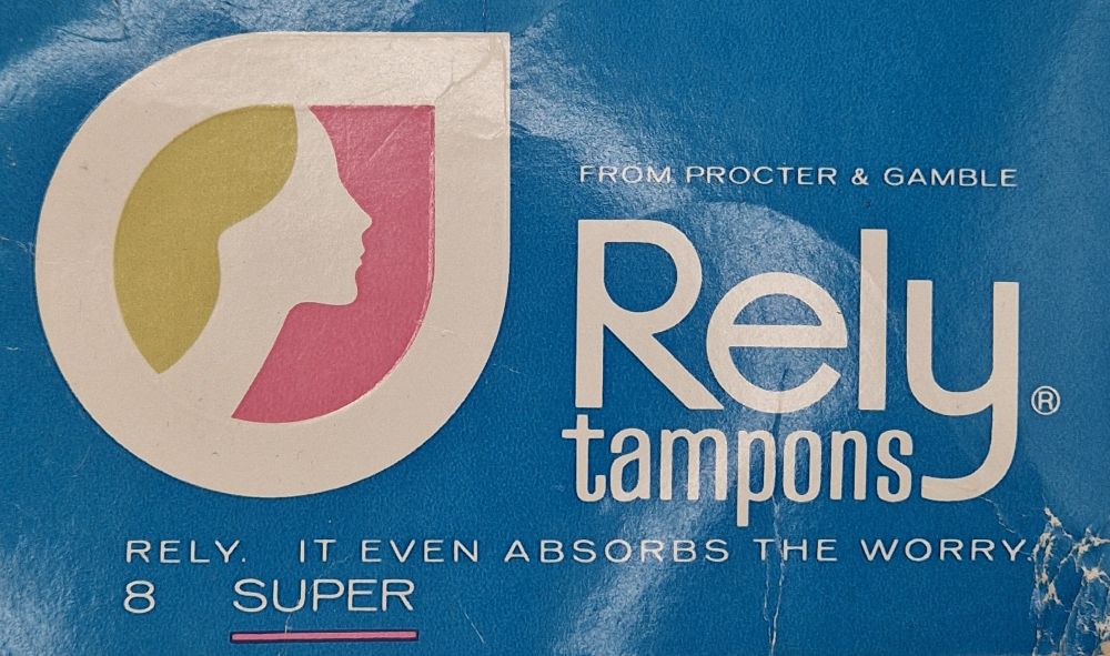 Photo of the front of the box of Rely brand tampons. It is blue with a logo design of a teardrop shape with a stylised, abstract side view of a woman's face. Branding says "From Procter & Gamble. Rely tampons. Rely. It even absorbs the worry. 8 super" 