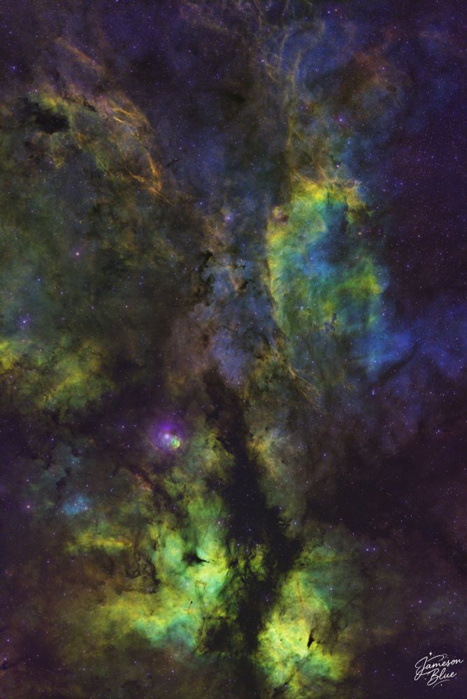 A cosmic butterfly spreads its fiery wings across a sea of stars — IC 1318, the Butterfly Nebula. Wisps of glowing red and orange gas twist and curl in space, set against the inky black of the universe. This vast emission nebula lies in the Cygnus constellation, about 4,000 lightyears from Earth.
