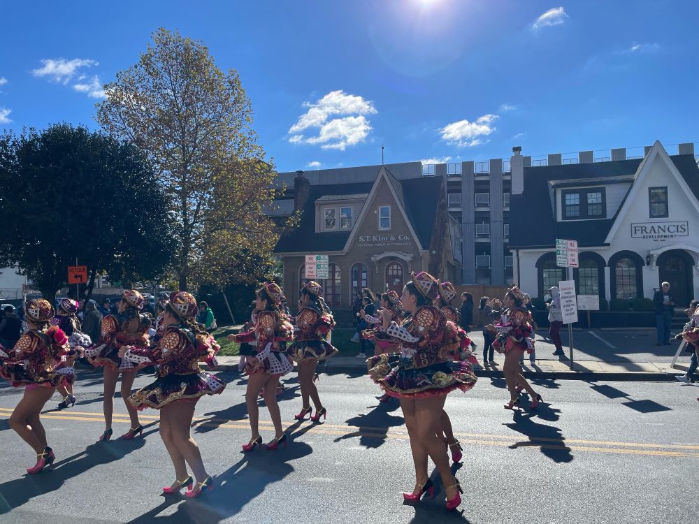 Dancers in parade twirling around in decorative dresses.