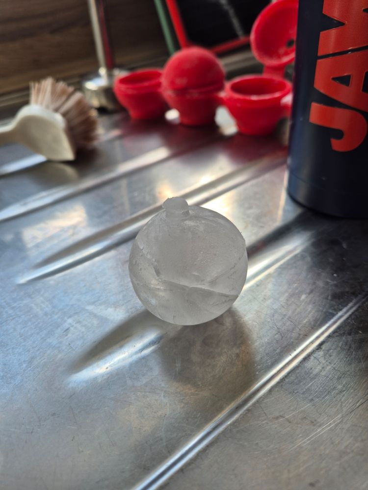 A round ice cube with a bit of smaller ice on it that looks like its nipple.