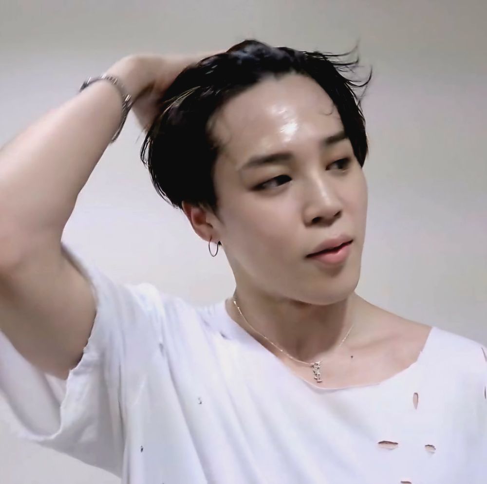 Sweaty Jimin wearing a white ripped T-shirt and a silver YSL logo necklace, brushing his hair back with one hand.