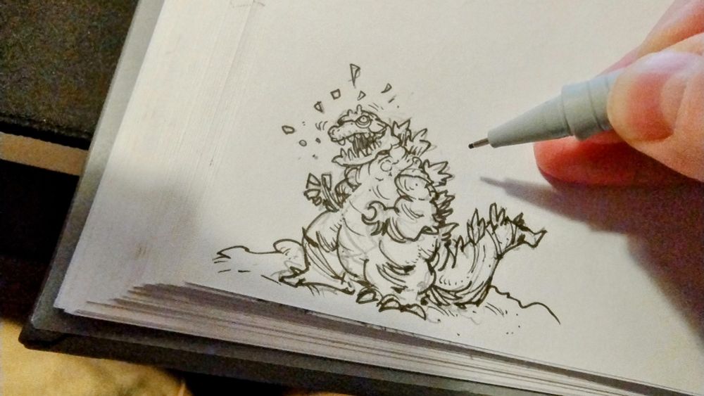 a tiny black and white drawing of a kaiju on paper