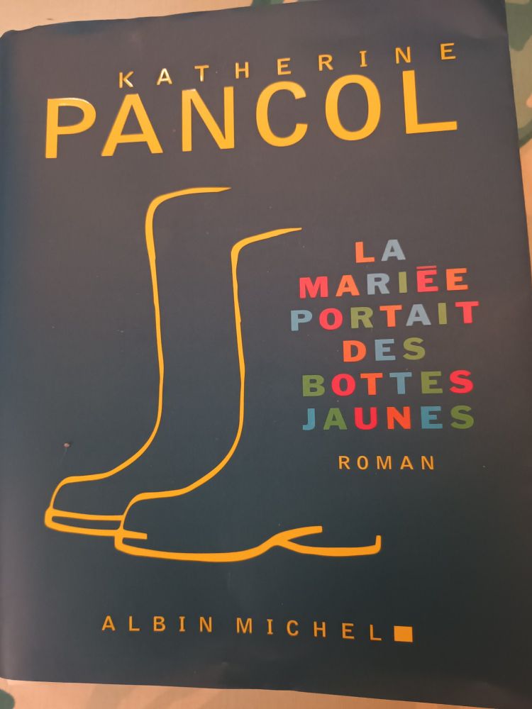 1e de couverture, contour de bottes jaunes sur fond vert sombre, titre écrit en lettres multicolores