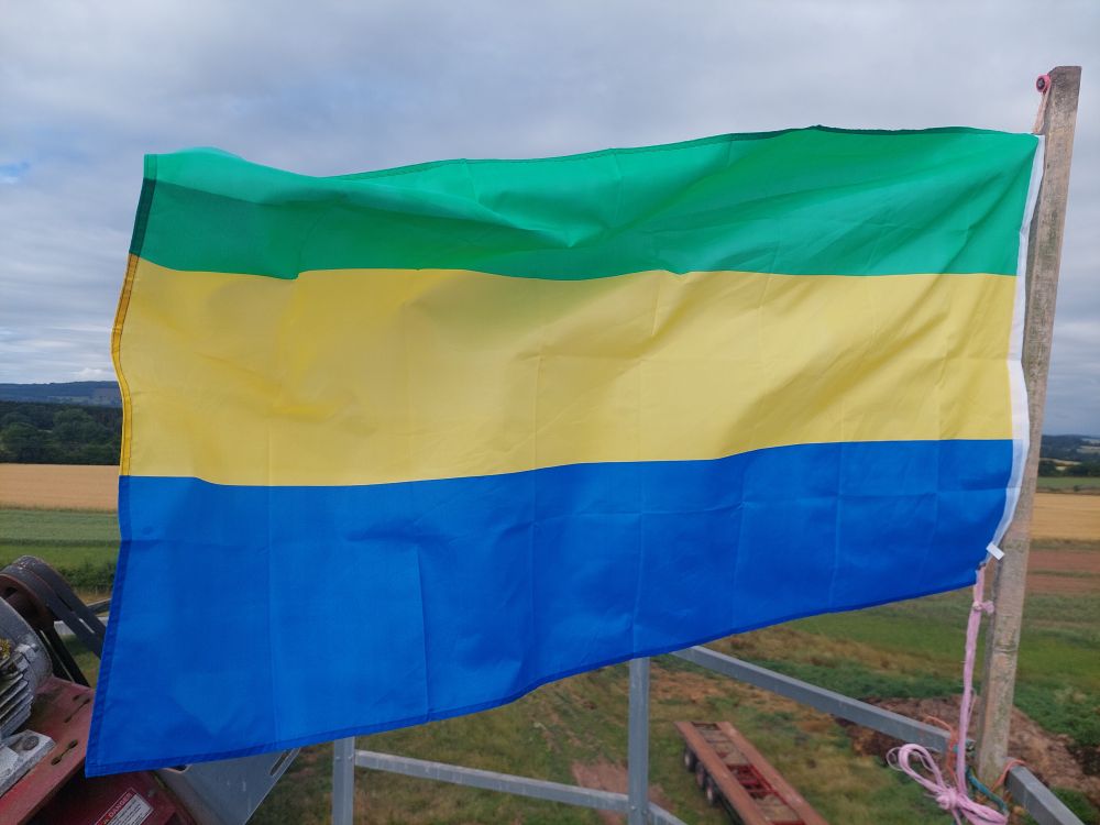 The Gabonese flag, a horizontal tricolour of green, yellow and blue.