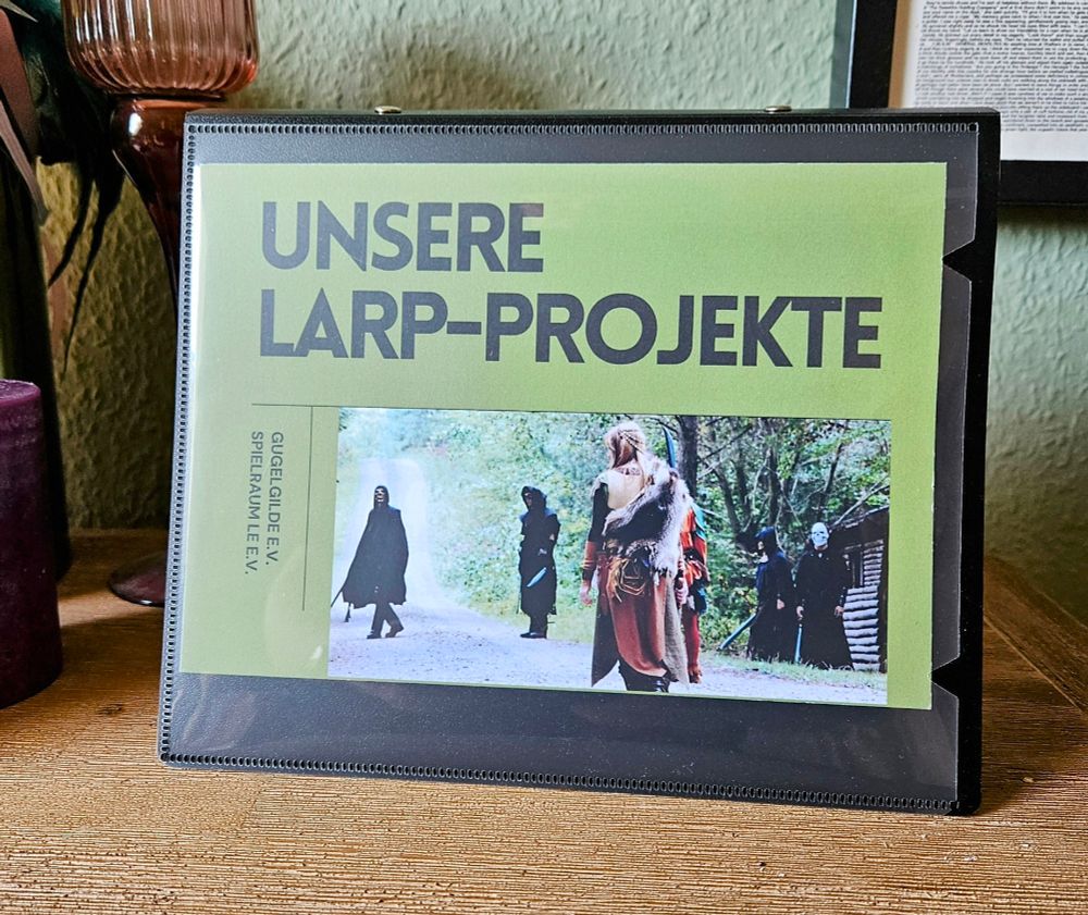 Ein Ordner mit dem Titelbild "Unsere LARP-Projekte" und "Gugelgilde e.V., Spielraum LE e.V." sowie einem Foto aus einem Fantasy-LARP.