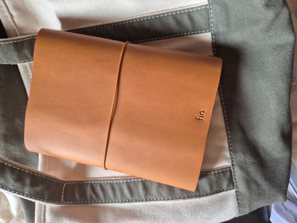 Rear view of leather journal cover showing the embossed name of the brand 'fin'