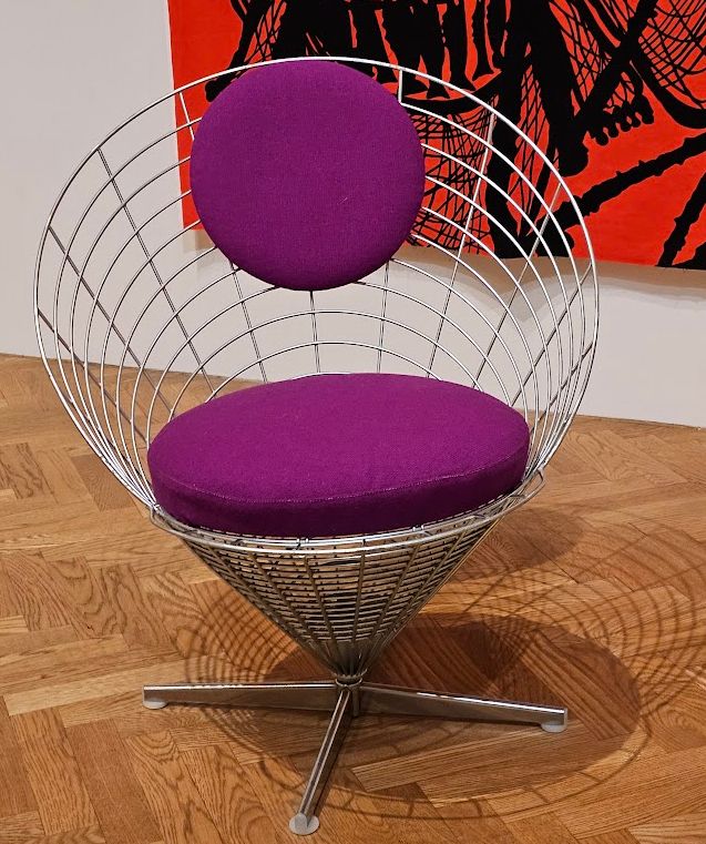 round wireframe chair with purple cushions sitting in the minneapolis institute of art.