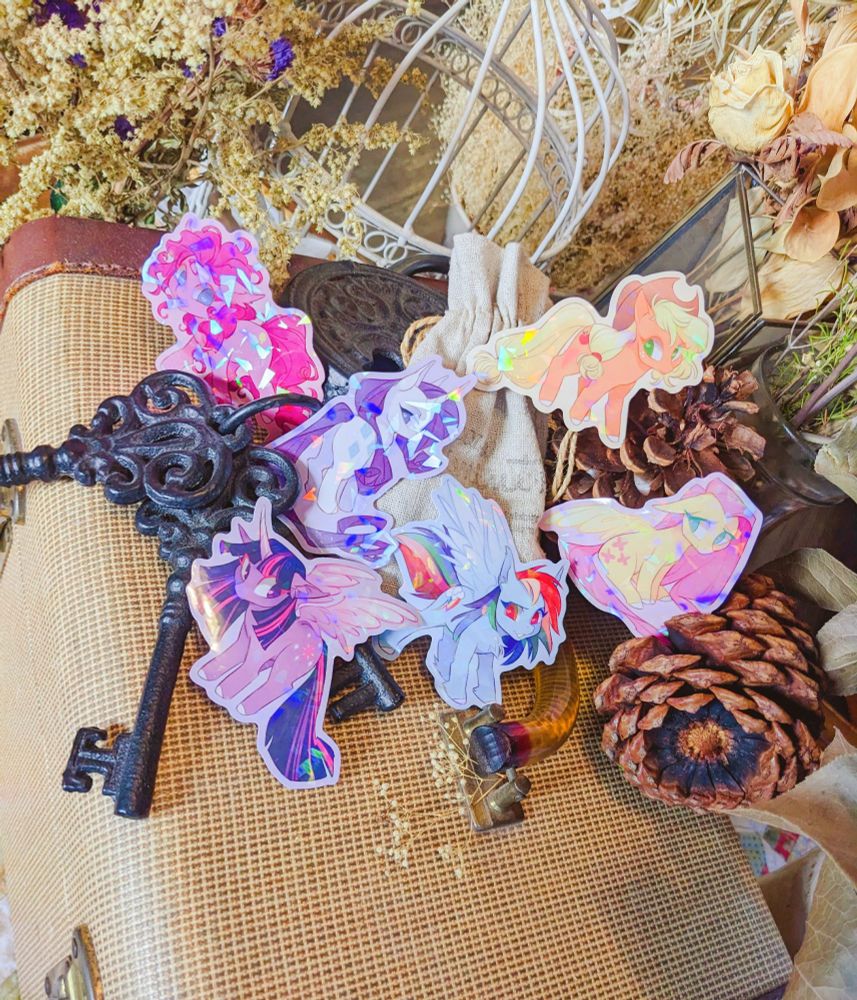 An example image of my holographic vinyl MLP stickers! Pictured are the Mane Six - set against a very rustic backdrop.
