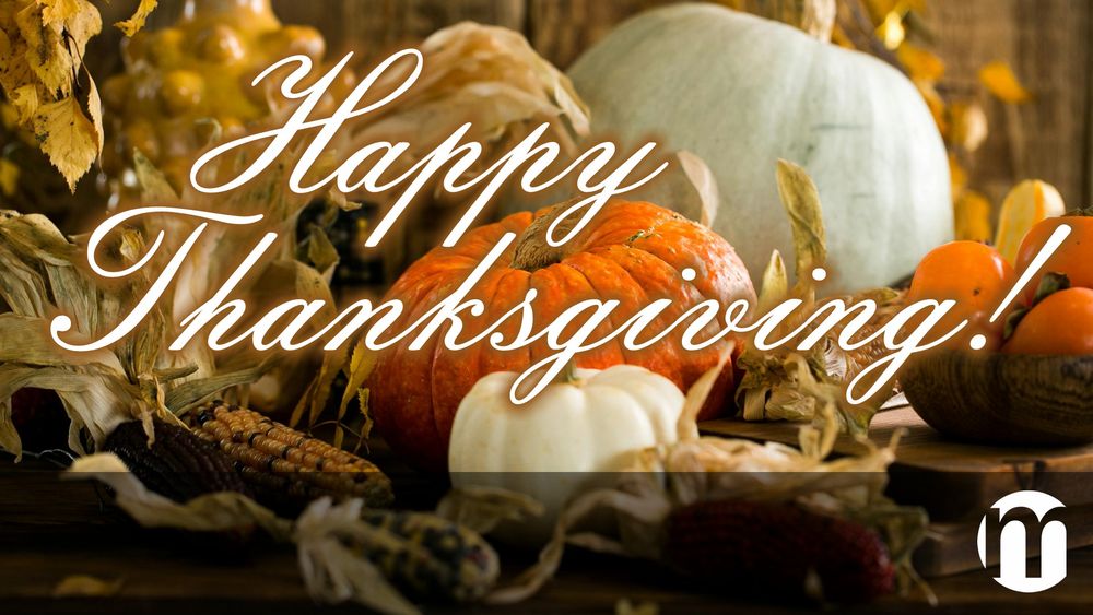 A photo of a variety of pumpkins, corn, and other vegetables and leaves. The words "Happy Thanksgiving" are written in script, and the Mirability logo is in the bottom right corner.