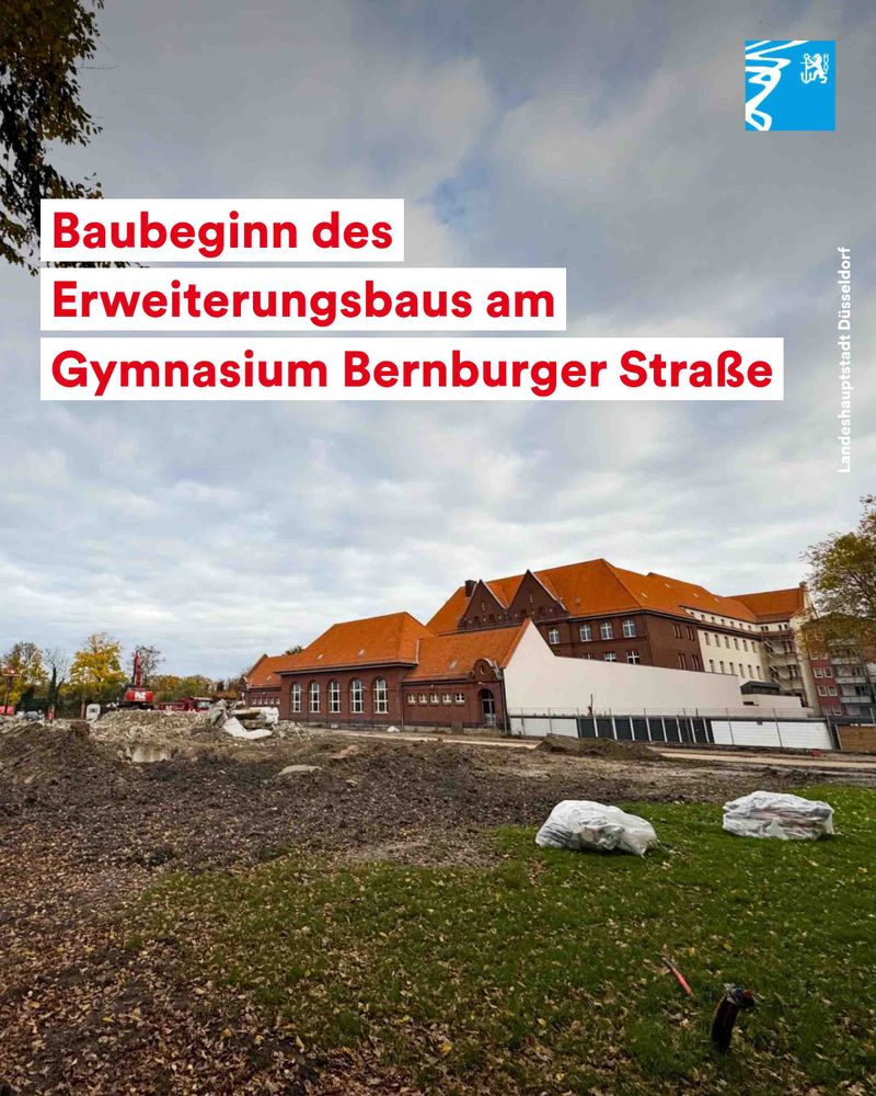Baustelle vor dem Gymnasium Bernburger Straße mit beginnendem Erweiterungsbau unter bewölktem Himmel.