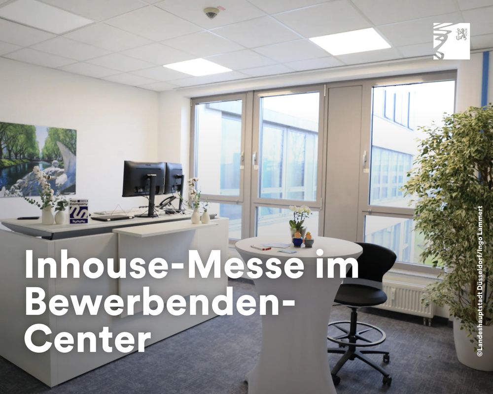 Modern eingerichteter Besprechungsraum mit Schreibtisch, zwei Monitoren und Stehtisch im Bewerbercenter.
