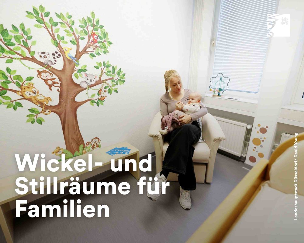 Eine Frau sitzt in einem gemütlichen Stillraum und hält ein Baby auf dem Schoß, umgeben von kindgerechter Wanddekoration mit Tiermotiven.