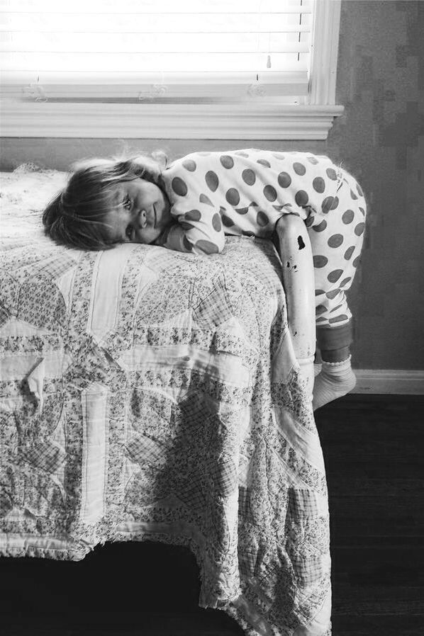 Cute kid lying at the end of a bed