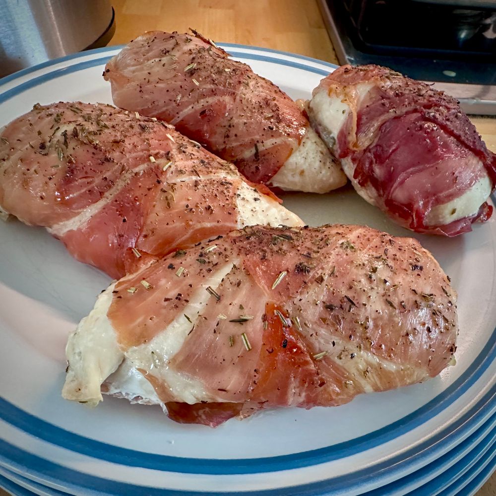A plate of four portions of chicken breast in Parma ham