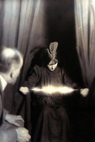Medium Eva Carrière photographed in 1912 with a light appearing between her hands