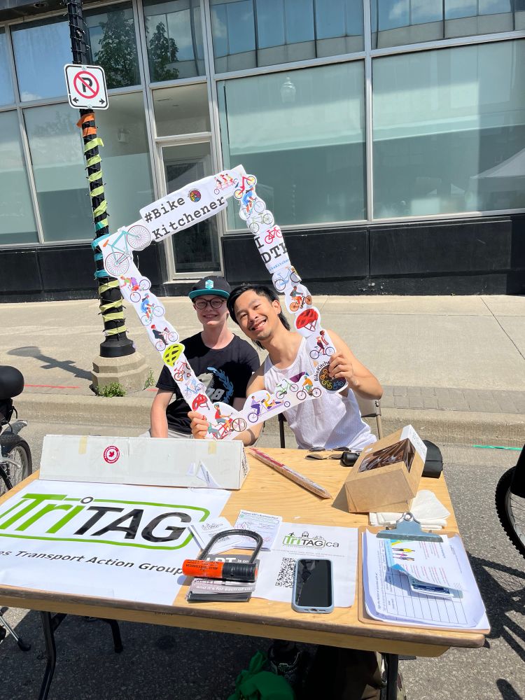 Rodney and Noah posing in a frame at the tritag table