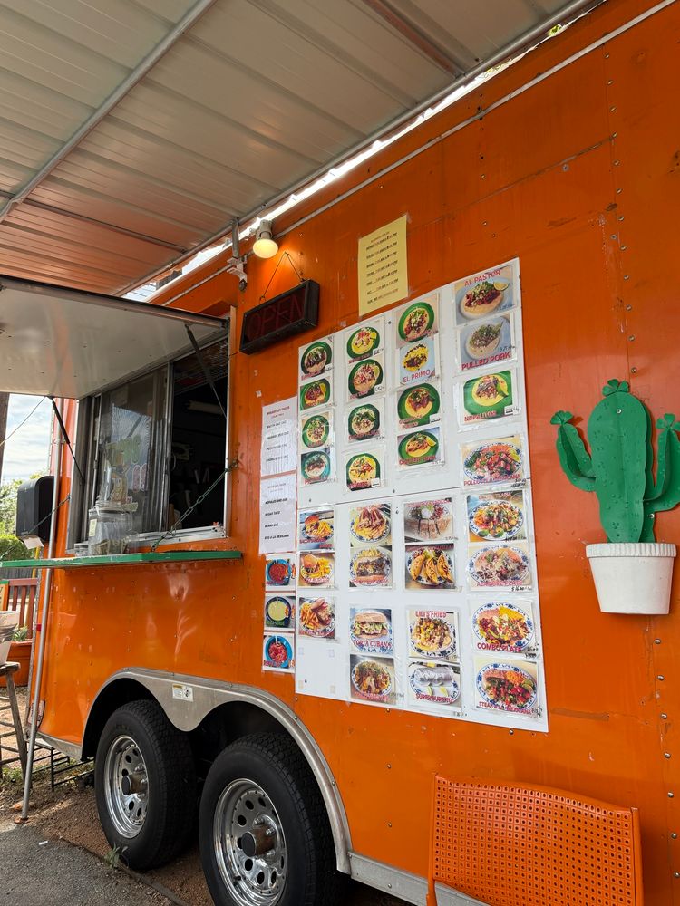 A taco truck with the menu on the side