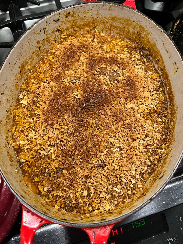 a stock pot showing a breadcrumb topping as the soup is finished 