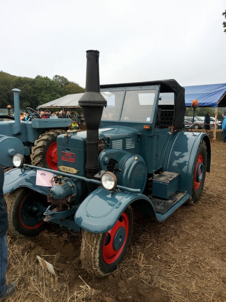 A very posh-looking vintage tractor, it's like a cross between a tractor and a 1930 saloon car. Viewed from the front left corner. 