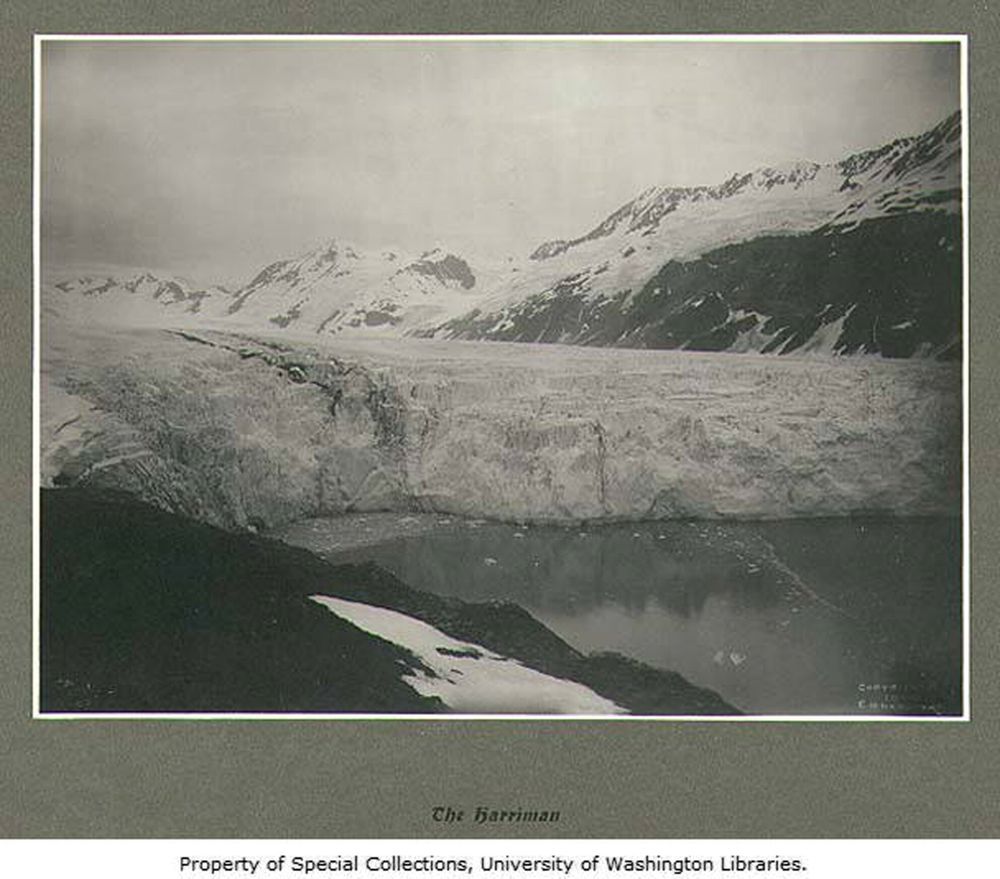 A historic black and white photograph of the 'Harriman' glacier with mountains in the distance.