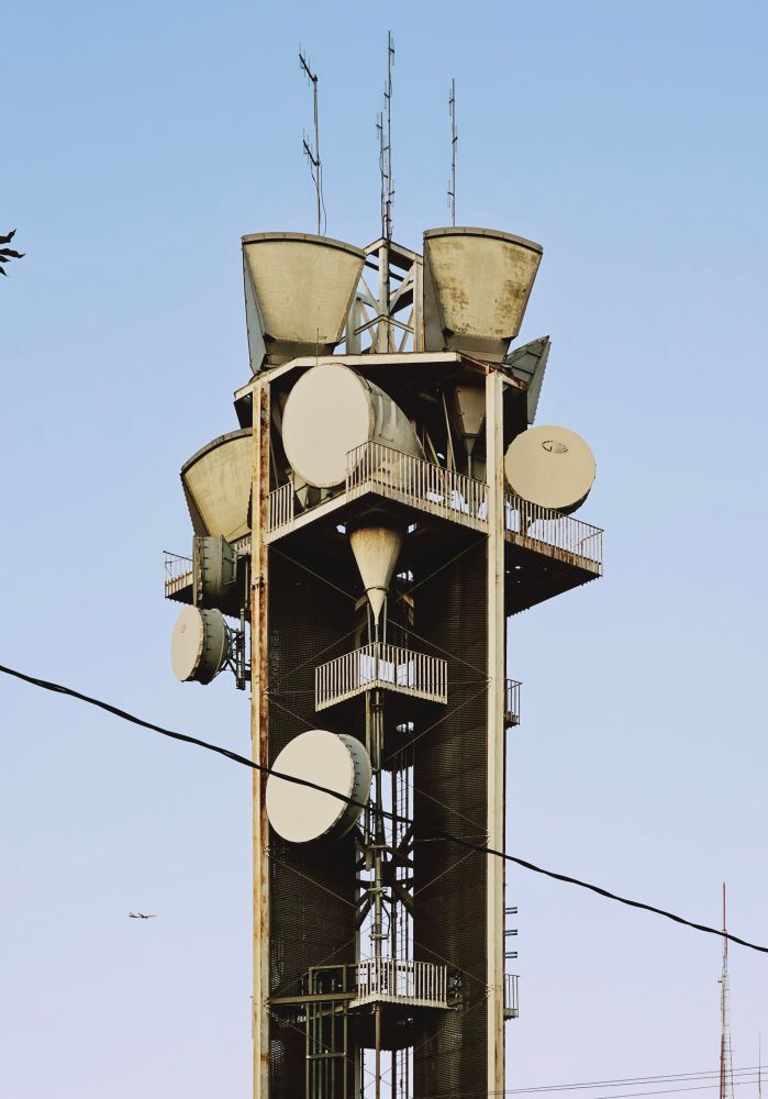 A picture of an old concrete tower with gigantic microwave horns perched atop. 