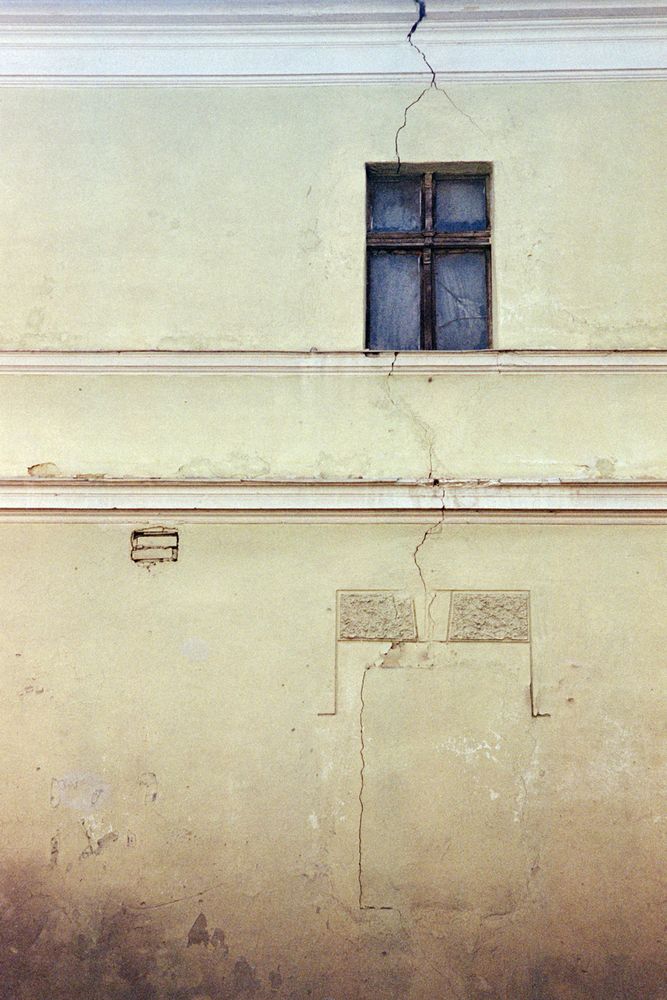 a wall with a window and a blank outline of a place where there presumably used to be one below