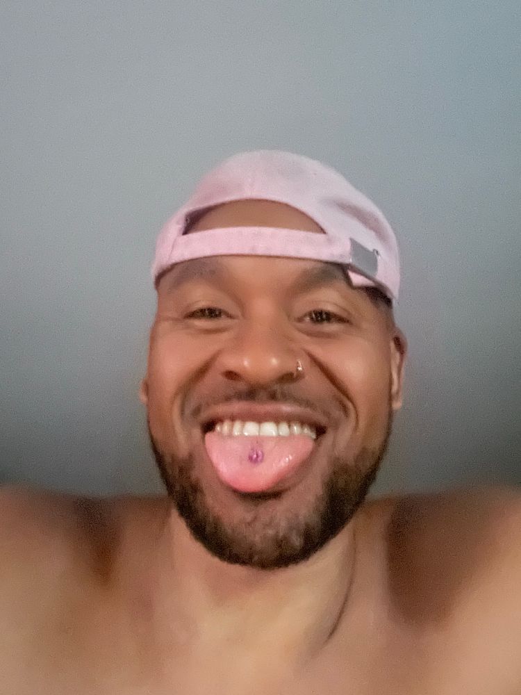 RM215 wearing a pink hat with tongue out