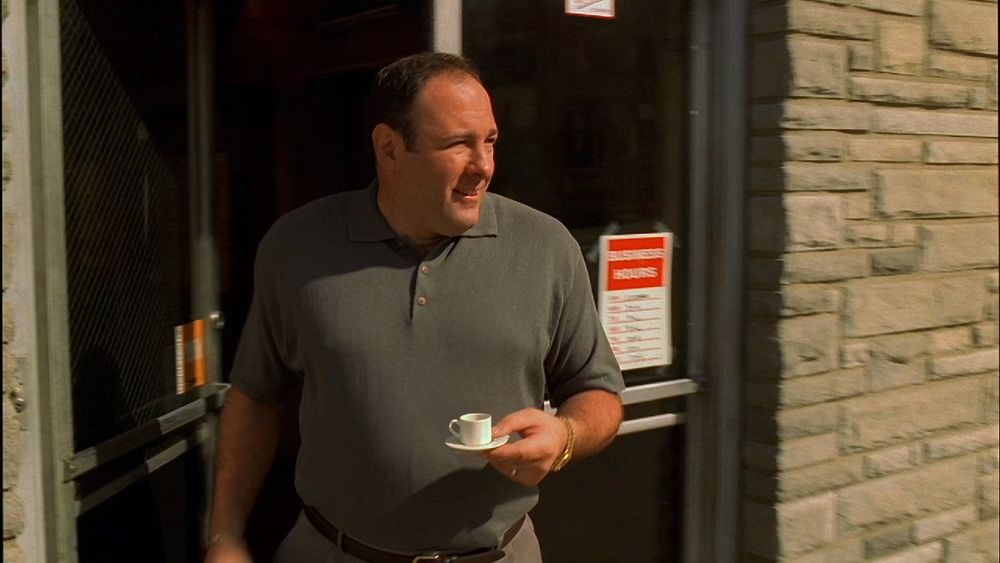 tony soprano holding a comically undersized coffee cup