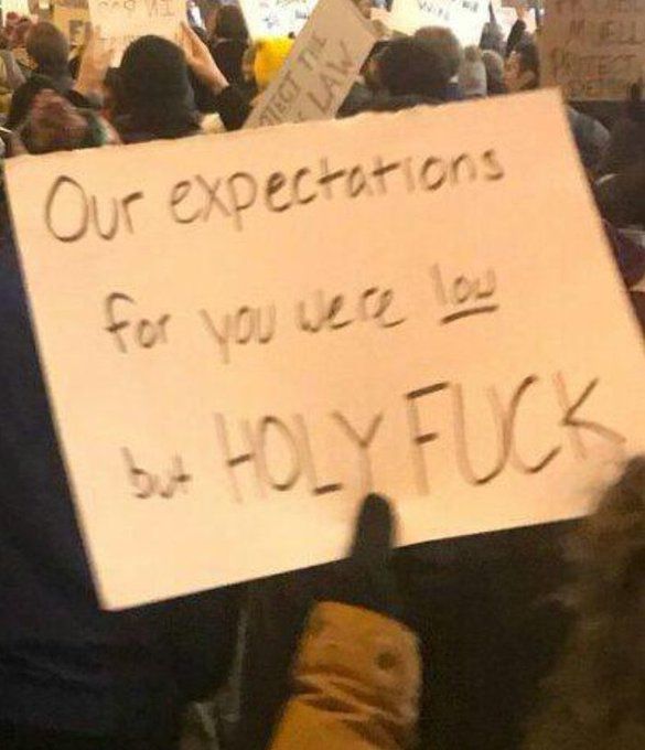 a poster board sign that reads "Our expectations for you were low but HOLY FUCK"